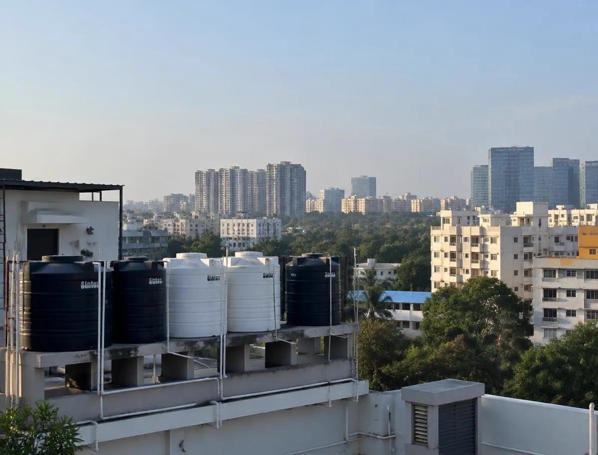 Row of overhead water tanks on an apartment rooftop in Whitefield